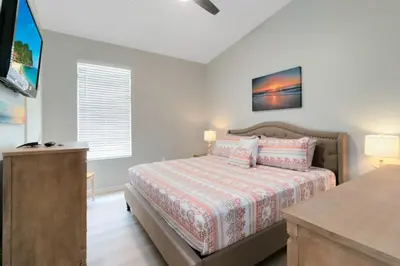 a bedroom with a bed and a dresser in it at Four Bed Pool/Spa Home-Windsor Palms Resort in Kissimmee