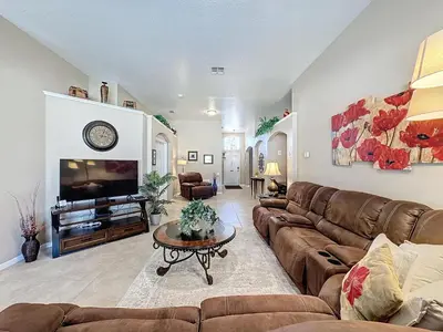 a living room with a couch and a tv at Tranquility Palms in a Resort- Steps to Disney in Kissimmee