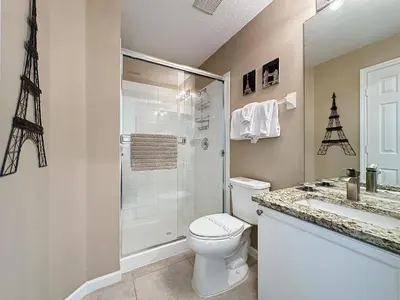 a bathroom with a toilet and a shower and a sink at Tranquility Palms in a Resort- Steps to Disney in Kissimmee