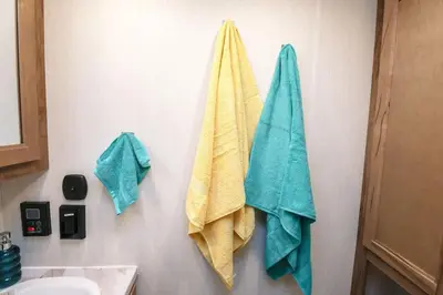 two towels hanging on a wall next to a sink at FunTropicalTinyHomeGolfCartLake in Orlando