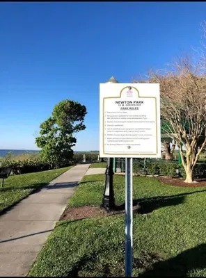 a sign in the grass next to a road at FunTropicalTinyHomeGolfCartLake in Orlando