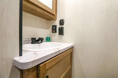a bathroom with a sink and a mirror at FunTropicalTinyHomeGolfCartLake in Orlando