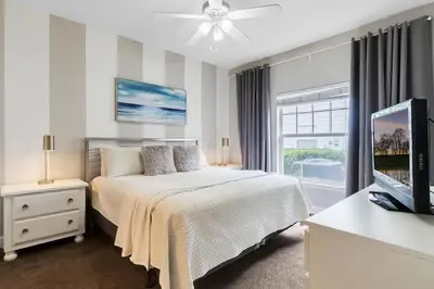 a bedroom with a bed and a flat screen tv at Casa 4Q + Sala de Jogos – 15 min da Disney in Kissimmee