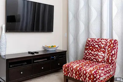 a living room with a chair and a tv at Dream 4814 Condo At Vista Cay in Orlando