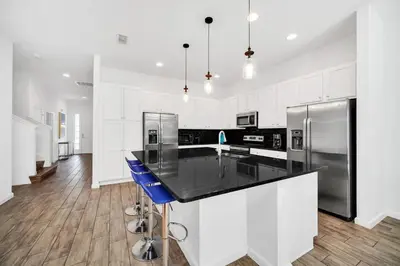 a kitchen with a black counter and a refrigerator at EPIC 12 Bedroom Home with Private Pool in Kissimmee