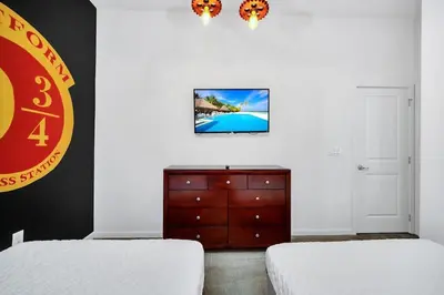 a bedroom with two beds and a dresser with a tv at EPIC 12 Bedroom Home with Private Pool in Kissimmee