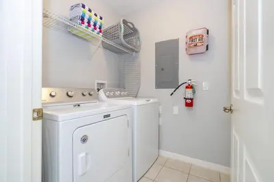 a white laundry room with a washer and dryer at Beautiful Townhouse In Bella Vida Resort in Kissimmee