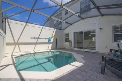 a swimming pool in the courtyard of a house at Beautiful Townhouse In Bella Vida Resort in Kissimmee