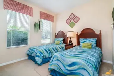 a bedroom with two beds and two windows at BellaVida Palms Private Screened Pool Home in Kissimmee