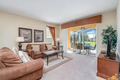 a living room with a couch and a table at BellaVida Palms Private Screened Pool Home in Kissimmee