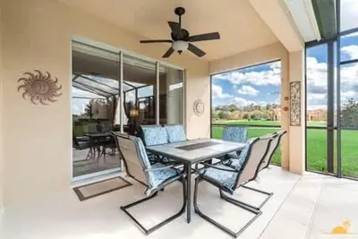 a dining room with a table and chairs and a ceiling fan at BellaVida Palms Private Screened Pool Home in Kissimmee