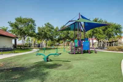 a park with a playground with an umbrella at BellaVida Palms Private Screened Pool Home in Kissimmee