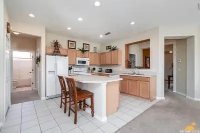 a kitchen with a table and chairs and a refrigerator at BellaVida Palms Private Screened Pool Home in Kissimmee
