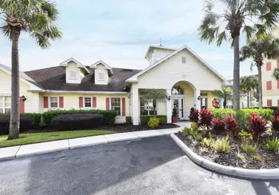 a house with palm trees and a driveway at Resort Condo with all amenities needed-Cane Island in Kissimmee