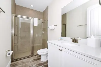 a white bathroom with a shower and a toilet at Key Lime Villa By The Lake Near Disney With Margaritaville Resort & Island H20 Waterpark Access - 3105Cs in Orlando