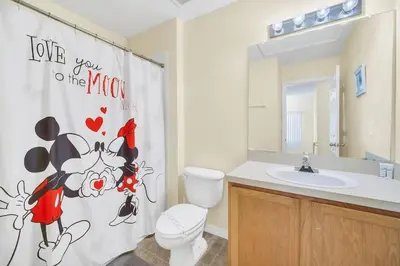 a bathroom with a toilet and a sink and a shower curtain at Townhome Perfectly Located Near Clubhouse in Kissimmee