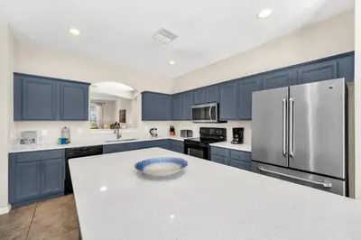 a kitchen with blue cabinets and a white counter top at Remodeled 7 Bedroom Retreat Near Disney World in Kissimmee