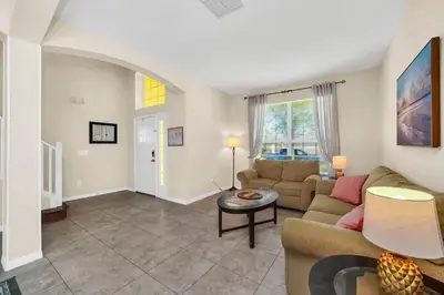 a living room with a couch and a table at Remodeled 7 Bedroom Retreat Near Disney World in Kissimmee