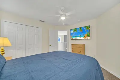 a bedroom with a blue bed and a ceiling fan at Emerald Island Resort 6 bedroom 4 bathroom luxury in Kissimmee