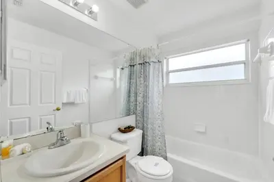 a bathroom with a sink and a toilet and a window at Cute Vacation Home Very Close to Disney in Orlando