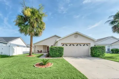 a house with a palm tree and a driveway at Cute Vacation Home Very Close to Disney in Orlando