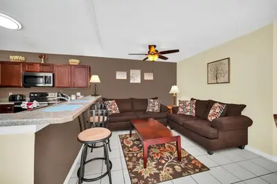 a living room with a couch and a kitchen at Lindfields Reserve with Private Pool in Kissimmee