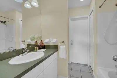a white bathroom with a sink and a shower at Lindfields Reserve with Private Pool in Kissimmee
