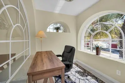 a home office with a wooden desk and a chair at Lindfields Reserve with Private Pool in Kissimmee