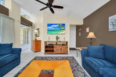 a living room with blue couches and a ceiling fan at Lindfields Reserve with Private Pool in Kissimmee