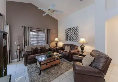 a living room with leather couches and a coffee table at Beautiful Pool Home by Disney World in Orlando
