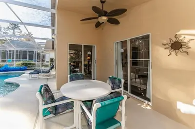 a dining room with a table and chairs and a pool at Beautiful Pool Home by Disney World in Orlando