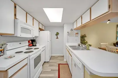 a kitchen with white counters and a white refrigerator at Beautiful Royal Palm Bay Condo near Disney in Kissimmee