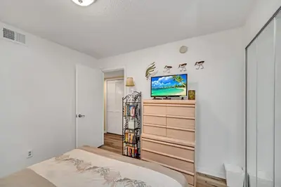 a bedroom with a bed and a flat screen tv at Beautiful Royal Palm Bay Condo near Disney in Kissimmee