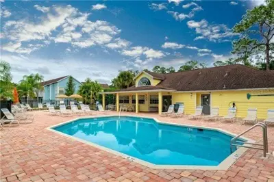 a house with a swimming pool in front of a house at Beautiful Royal Palm Bay Condo near Disney in Kissimmee