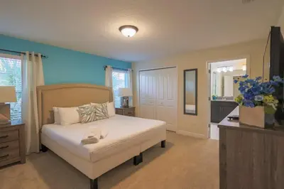 a bedroom with a white bed and a blue wall at Magical Townhome private pool in Storey Lake in Kissimmee