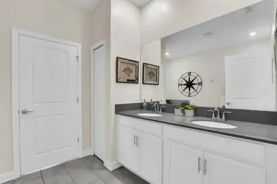 a bathroom with two sinks and a large mirror at Storey Lake Dream Villa with Private Pool in Kissimmee