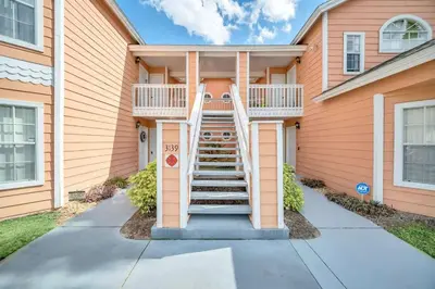 a house with a staircase in front of it at Incredible Island Club Villa Condo in Kissimmee