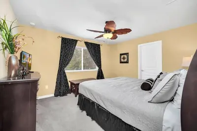 a bedroom with a bed and a ceiling fan at Windsor Hills Dream Private Screened Pool Home in Orlando