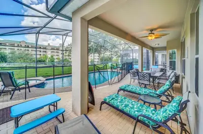 a screened porch with chairs and a swimming pool at Windsor Hills Dream Private Screened Pool Home in Orlando