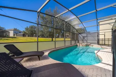 a swimming pool in a glass house with a table and chairs at Luxury 6 Bedroom Pool Home in Windsor Hills in Orlando