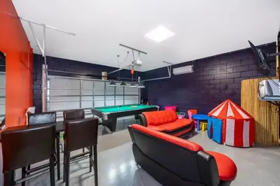 a room with a ping pong table and chairs at Luxury 6 Bedroom Pool Home in Windsor Hills in Orlando