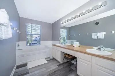 a bathroom with two sinks and a large mirror at Luxury 6 Bedroom Pool Home in Windsor Hills in Orlando