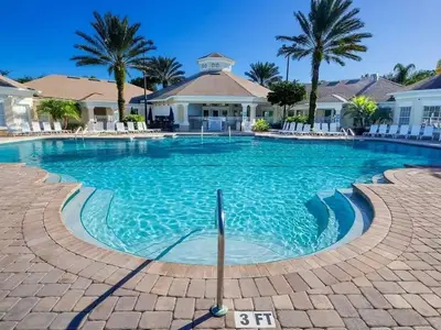 a swimming pool at a resort with palm trees at 3 Bedroom 2 Bath Condo in Windsor Palms Resort in Kissimmee