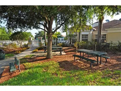 a picnic table and benches in a park with a tree at Newly Remodel Kitchen with All New Appliances in Kissimmee
