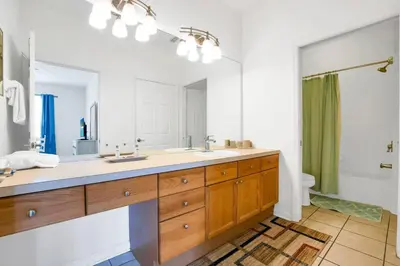 a bathroom with two sinks and a large mirror at Beautiful Vacation Condo at Windsor Palms Resort in Kissimmee
