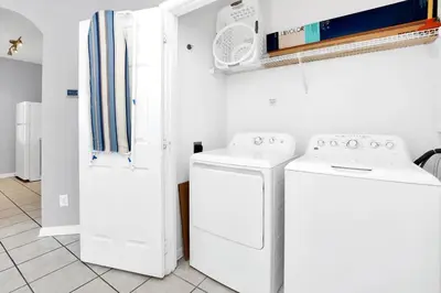 a laundry room with two washing machines and a refrigerator at Beautiful Vacation Condo at Windsor Palms Resort in Kissimmee