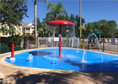 a small pool with a fountain in a park at Beautiful Vacation Condo at Windsor Palms Resort in Kissimmee