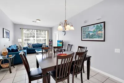 a dining room and living room with a table and chairs at Beautiful Vacation Condo at Windsor Palms Resort in Kissimmee
