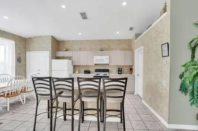a kitchen with chairs and a table in a room at Windsor Palms Villa with Very Private Pool in Kissimmee