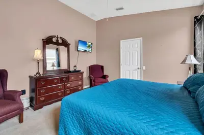 a bedroom with a blue bed and a dresser and a mirror at Windsor Palms Villa with Very Private Pool in Kissimmee